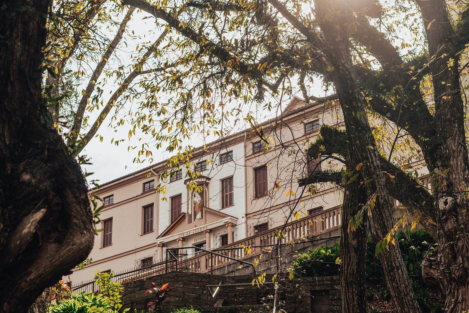 Mosteiro Hotel de Charme, em Garibaldi, visto entre as árvores ao entardecer