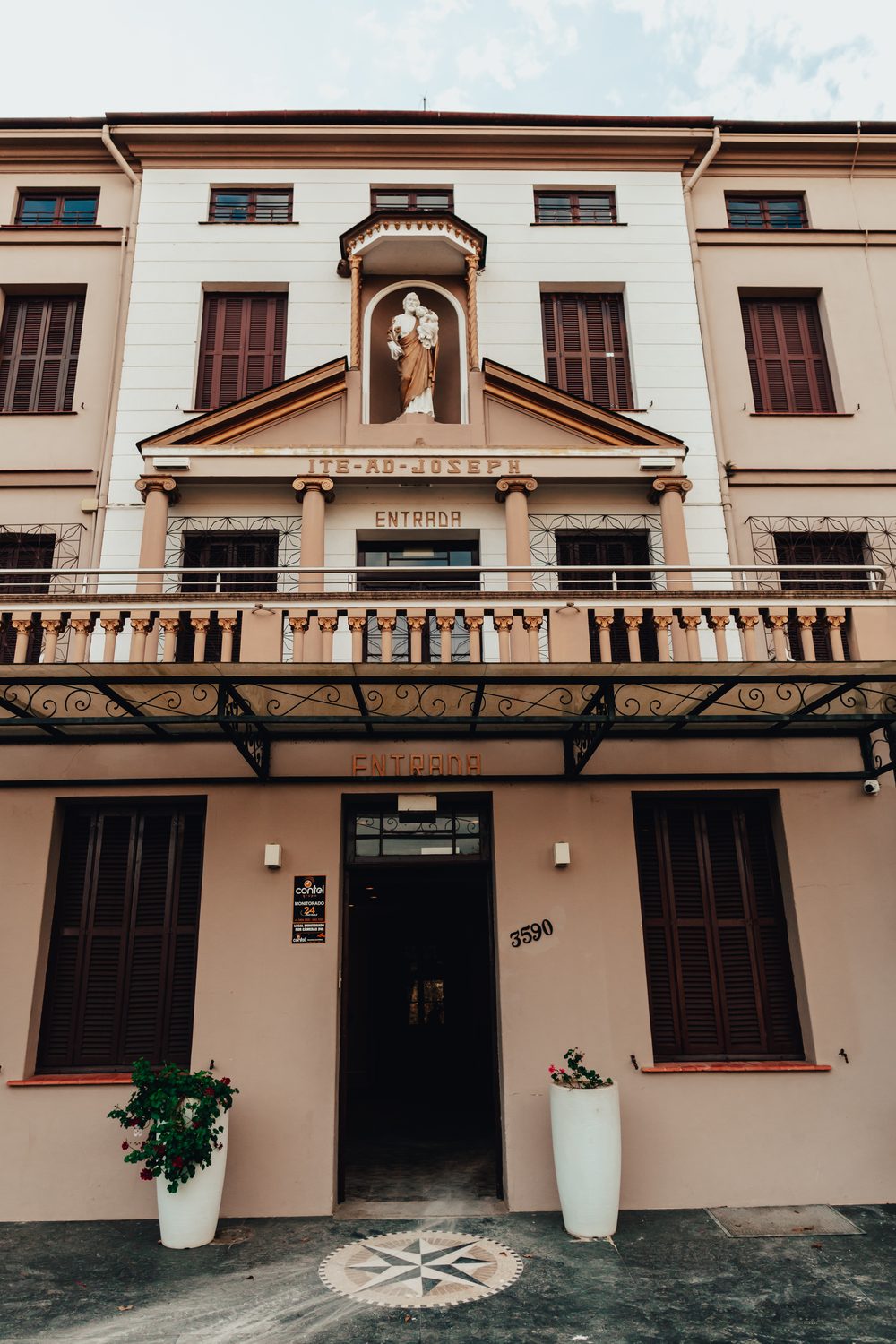 Fachada histórica do Mosteiro Hotel de Charme com a inscrição Ite ad Joseph