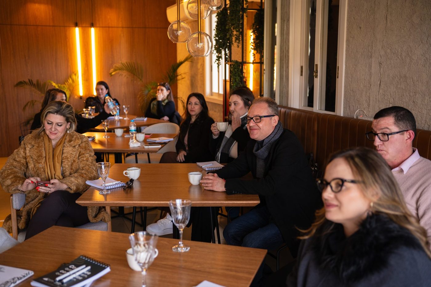 Empresários reunidos em volta das mesas durante um encontro do Eruption Club